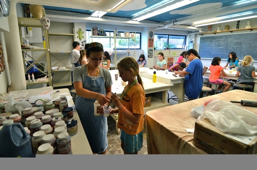 Glazing her first piece in ceramics!